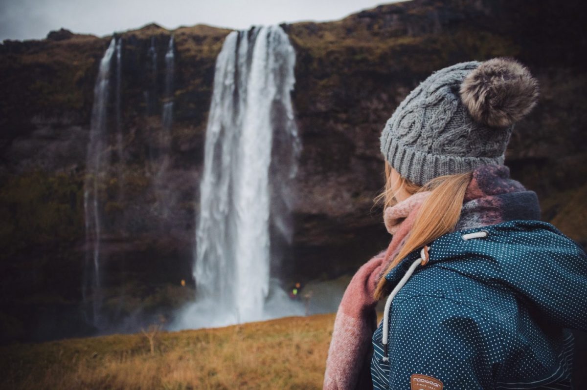 girl looking at seljalandsfoss waterfall