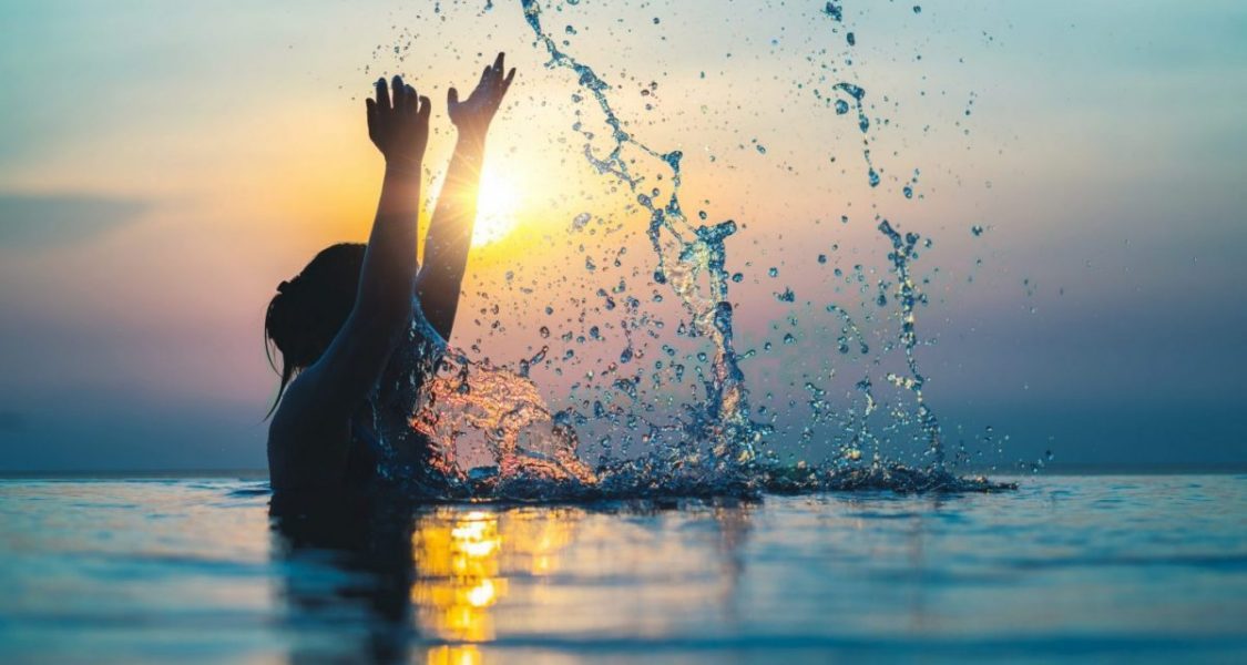 Femme jouant avec l'eau dans une piscine islandaise